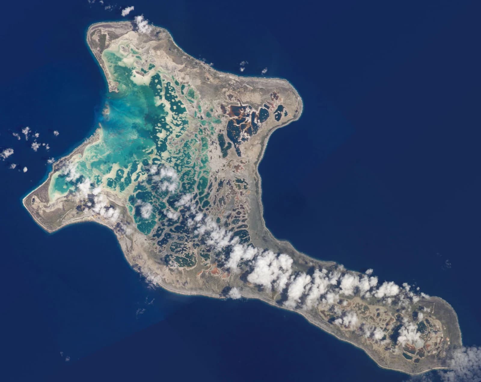 Satellite photograph of Kiritimati showing its broad coral landmass, turquoise lagoons and dark Pacific water.