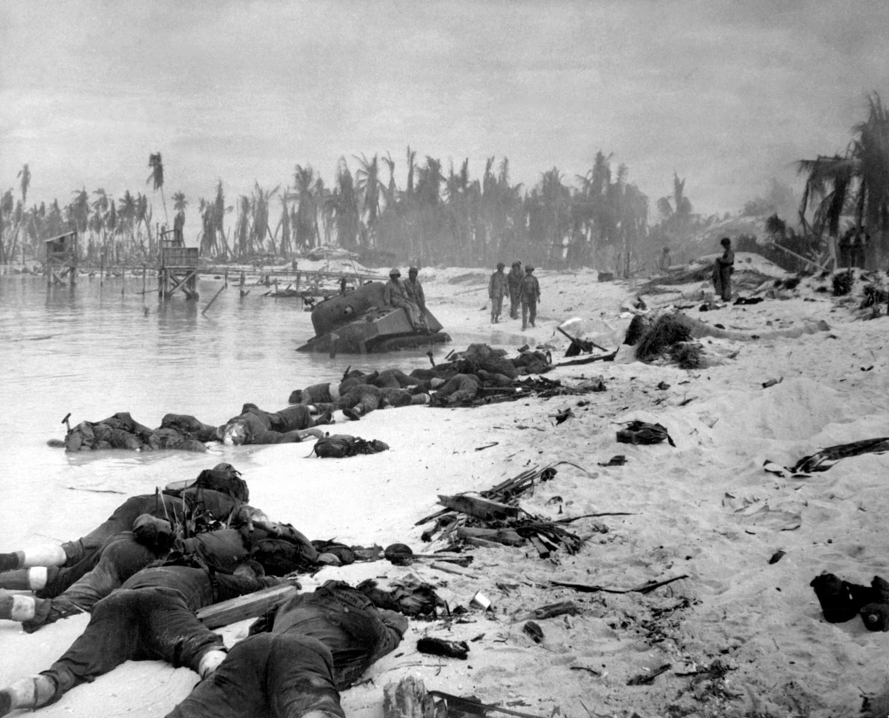 Black-and-white 1943 photograph of dead United States Marines on a damaged beach at Tarawa after the assault.