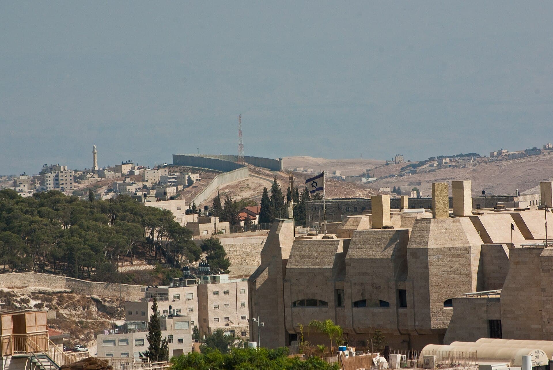 The concrete West Bank barrier curves across hills and built-up areas near Jerusalem, seen from a distance in 2010.