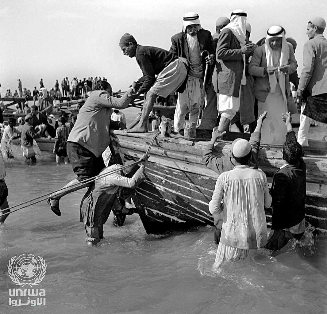 Palestinian refugees climb into crowded fishing boats while leaving the Gaza Strip in 1948.